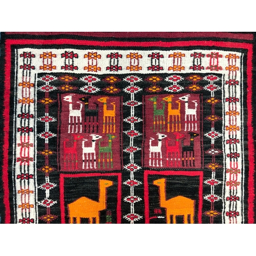 641 - An Ecuador flatweave rug - late 20th century, the charcoal ground with six panels with stylised llam... 