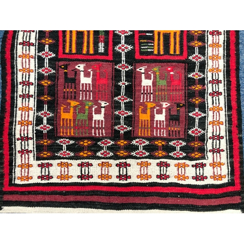 641 - An Ecuador flatweave rug - late 20th century, the charcoal ground with six panels with stylised llam... 