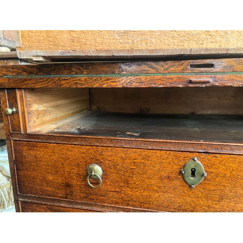 498 - A mid-18th century oak bachelor's chest - the rectangular fold-over top opening on lopers, lined wit... 