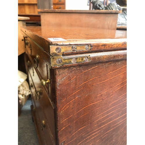 498 - A mid-18th century oak bachelor's chest - the rectangular fold-over top opening on lopers, lined wit... 