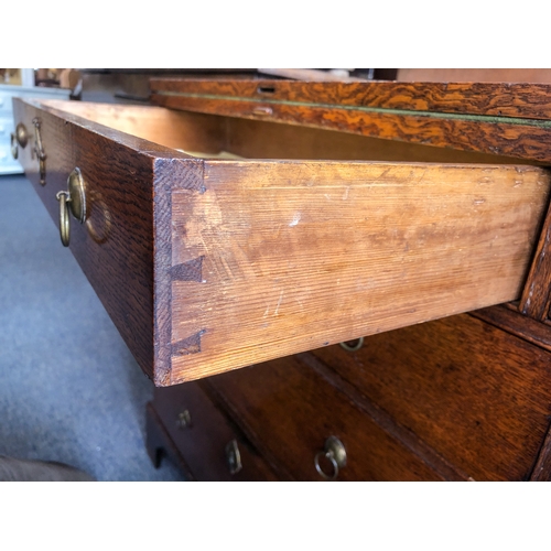 498 - A mid-18th century oak bachelor's chest - the rectangular fold-over top opening on lopers, lined wit... 