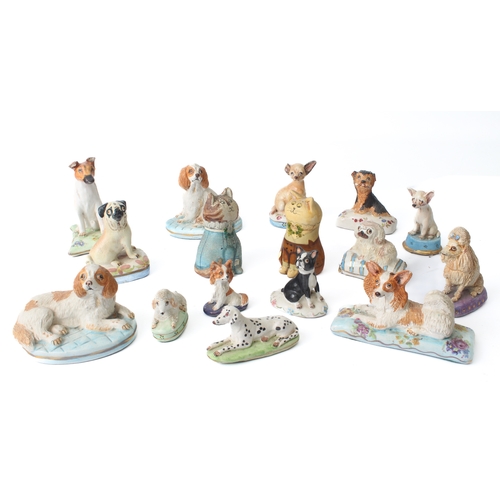 20 - A small group of pottery miniatures figures of dogs by Basil Matthews – each seated upon a decorativ... 