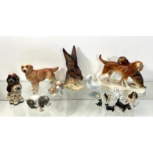 47 - A collection of bone china and pottery figures of dogs - 1960s-90s, including a Royal Dux group with... 