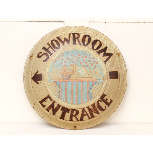 1037 - A stoneware studio pottery 'Showroom Entrance' plaque - the central reserve painted with a bowl of f... 