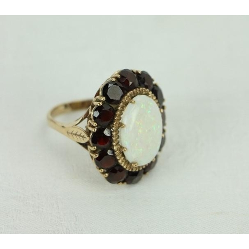 515 - An unusual 18ct gold Ladies Ring, with attractive central oval shaped opal stone, surrounded by 12 l... 