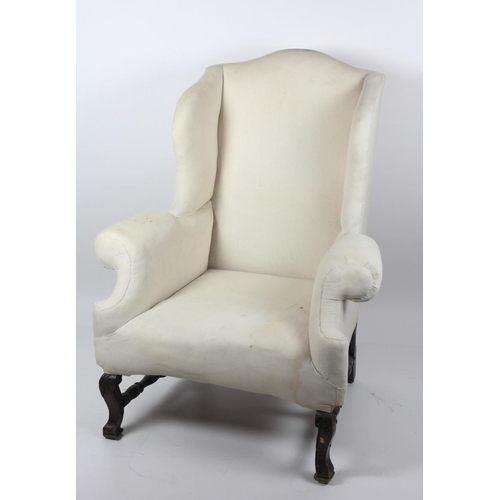 291 - A heavy antique wing back Armchair, on turned H shaped stretcher, and carved front legs. (1)