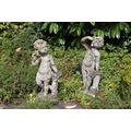 Two Victorian style composition Statues of young Children, depicting a young boy listening to a shel... 