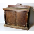 A stained oak Side Cabinet, with shaped back, over two panel doors, flanked by pillar supports, a pa... 