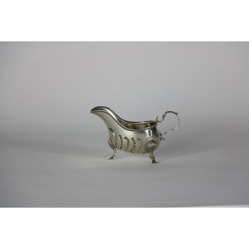 130 - A 19th Century Irish silver Sauceboat, with reeded rim and C scroll handle on shell decorated pad fe... 