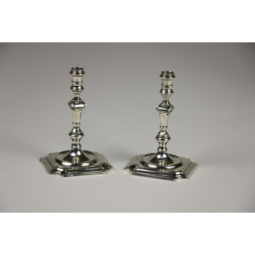 418 - An unusual pair of cast silver taper Candlesticks, in the George II style, London 1976, each on squa... 