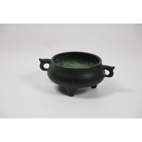 654 - A heavy Chinese bronze Censor, the ogee shaped circular body with two handles on three legs and a sq... 