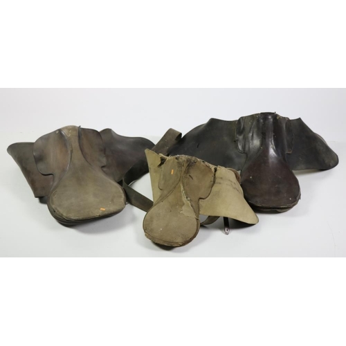 77 - Two early leather Saddles, and a Child's Saddle (worn) with iron wall mount. (3)