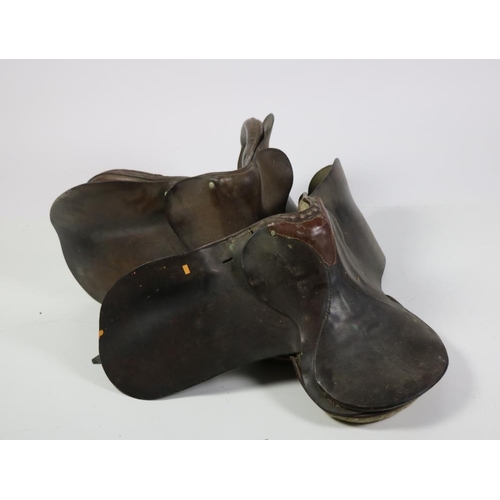 79 - A leather Saddle  by Gibsons, Newmarket and an earlier similar Saddle, and an iron Wall Mount. (3)