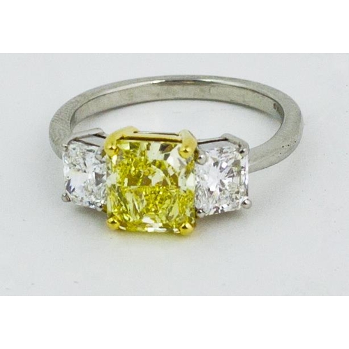 102 - An exquisite 3 stone diamond Ring, with 2.93ct fancy intense yellow centre stone (VS2) flanked by tw... 