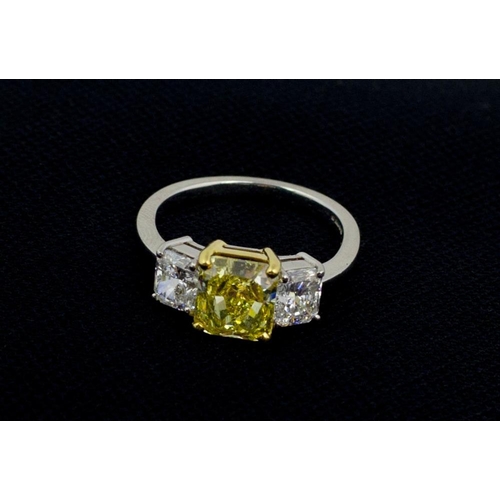 102 - An exquisite 3 stone diamond Ring, with 2.93ct fancy intense yellow centre stone (VS2) flanked by tw... 