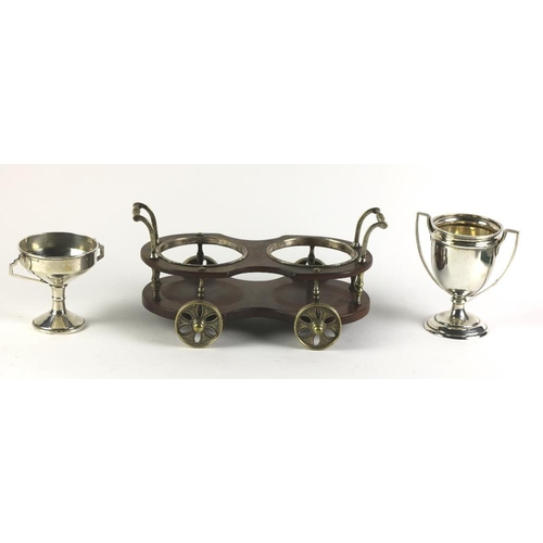 23 - Two small white metal (Indian silver) two handled Cups, and a two bottle Table Coaster modelled as a... 
