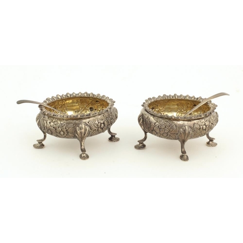 52 - A pair of Victorian silver Salts, embossed with floral decoration and pad feet, with matching spoons... 
