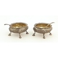 A pair of Victorian silver Salts, embossed with floral decoration and pad feet, with matching spoons... 