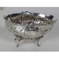 An oval bath shaped silver Bowl, with extensive repousse decoration of scrolls, birds and rose heads... 