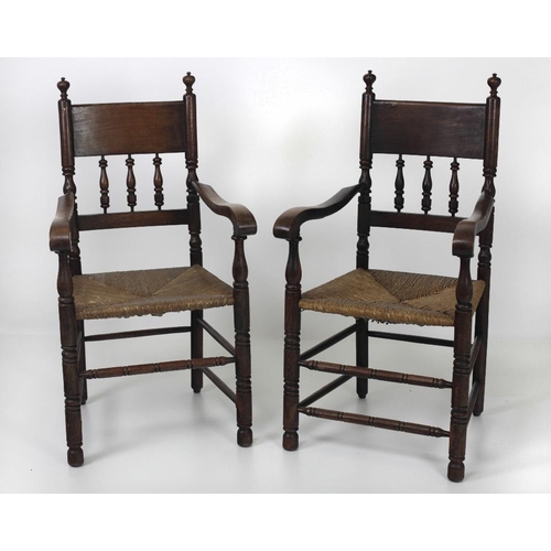 710 - A pair of Irish oak cottage Armchairs, the backs with turned spindle supports over sugan type seats ... 