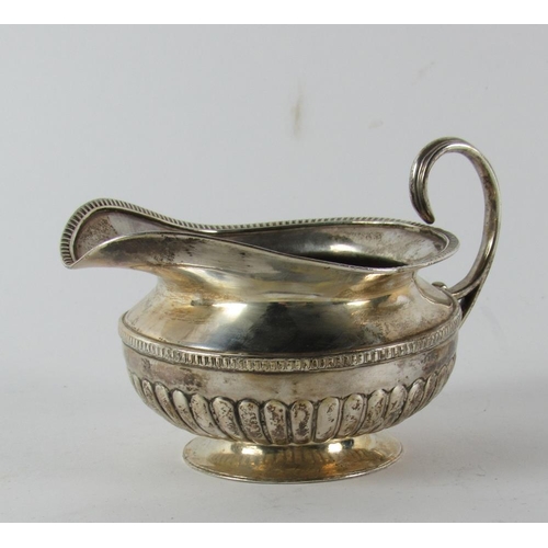 41 - A circular Irish Georgian silver Cream Jug, with gadroon edge and half fluted body, by James le Bass... 