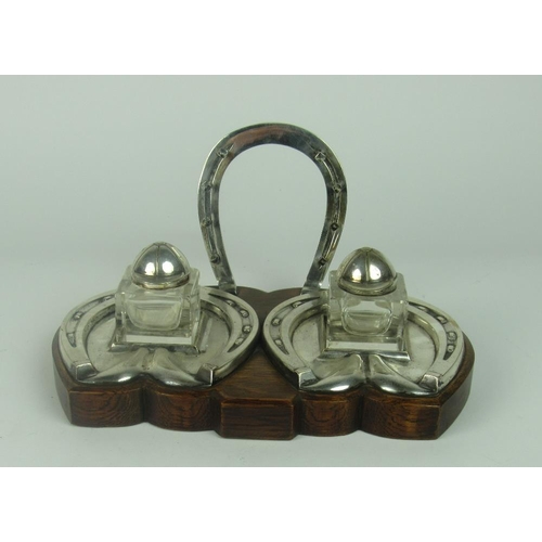 53 - An unusual silver plated Desk Companion, on an oak stand, decorated with horse-shoe shaped pen holde... 