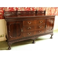 A Chippendale style carved mahogany Sideboard, with fretwork back rail, three long centre drawers fl... 