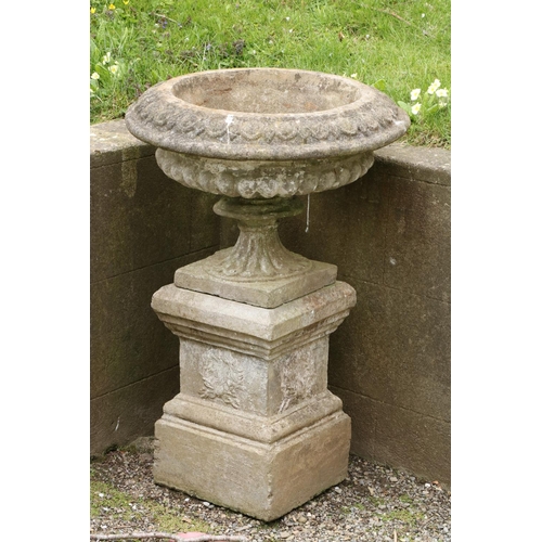 590 - A nicely weathered composition stone Urn and plinth, with half reeded body. (1)