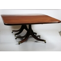 A large Regency period mahogany twin pedestal Dining Table, with two spare leaves, raised on twin qu... 