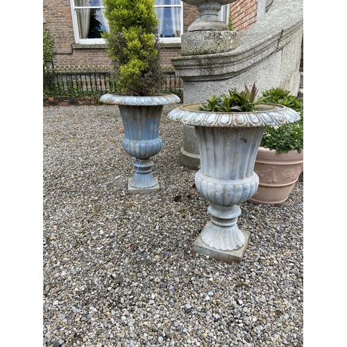 106 - A set of 4 heavy cast iron Garden Urns, each with egg and dart moulded folded rim and ribbed body on... 