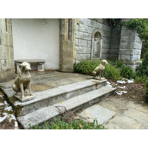 127 - A pair of composition Garden Figures, each modelled as a life size seated hound, 27'' (69cms) h. (2)... 