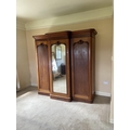 A fine Victorian mahogany breakfront Wardrobe, with moulded cornice above a centre mirror door and a... 