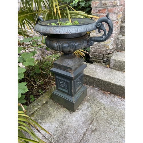 131 - A pair of heavy cast iron Garden Urns, each with folded rim and half reeded body with two leaf scrol... 