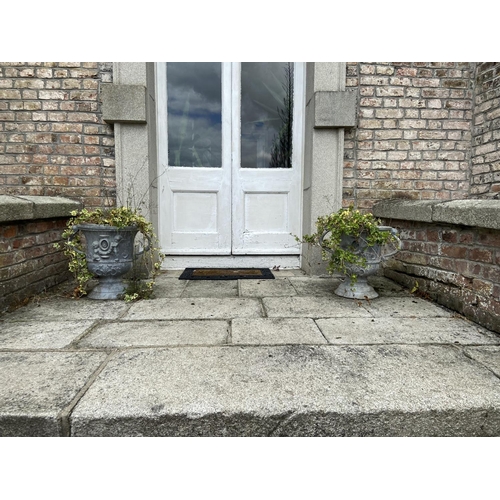 133 - A pair of good quality two handled lead Garden Urns, each with two cherubs, flanking an urn with flo... 