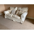A two seater Easy Settee, covered in ivory fabric and loose cushions, 68'' (172cms). (1)... 