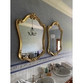 A pair of cartouche shaped gilt Mirrors, each in scroll moulded frame, 43'' x 21'' (109cms x 79cms).... 