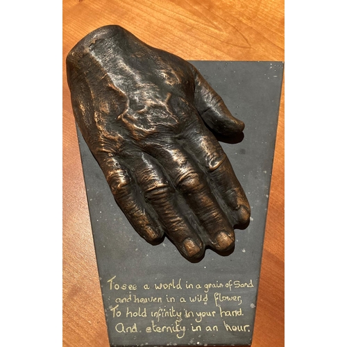 605 - Orla de Bri, Irish A bronze Model of a Man's hand mounted on shaped Valentia slate, inscribed 