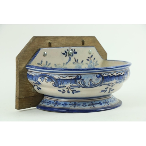 112 - A Continental blue and white Faience demi-lune wall mounted Basin, with armorial crest and decorated... 