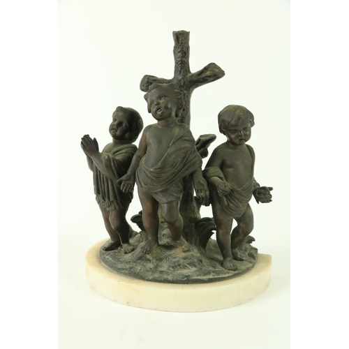 818 - A Religious bronze Group, modelled with three cherubs in prayer by a tree stump in the form of a cro... 