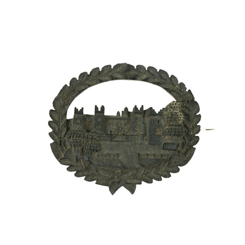 867 - A rare 19th Century Irish carved bog oak Brooch, with view of Howth Castle, in a carved oval wreath,... 