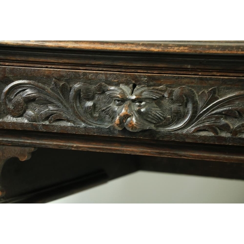 171 - An oak 17th Century style kneehole Desk, profusely carved with scrolling foliage and animal masks on... 