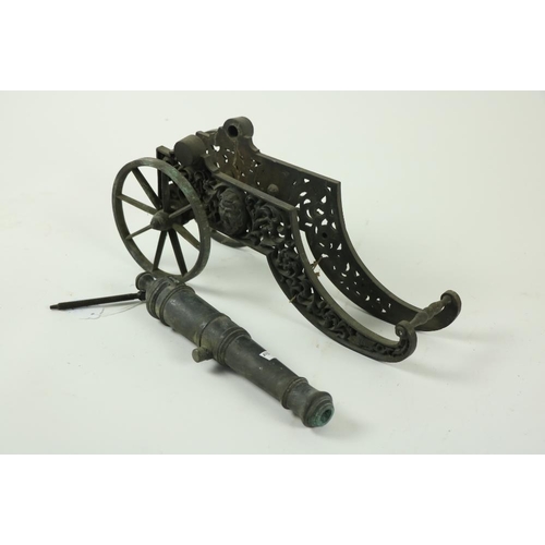 828 - A very heavy Continental cast bronze Floor Cannon, 19th Century, the two wheel carriage with grotesq... 