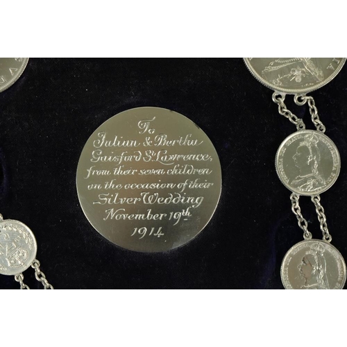 878 - A cased set of Victorian and George V silver Coins, with chain link, with inscribed central coin 