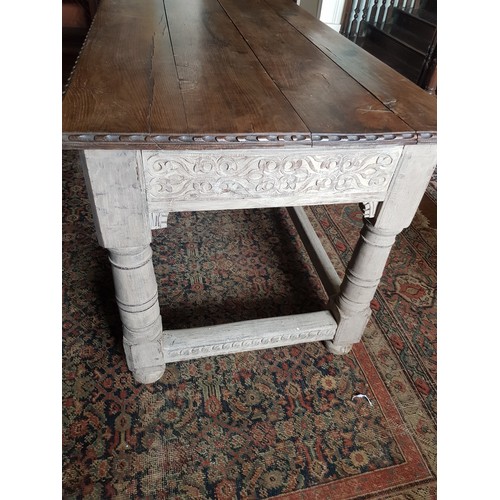 327 - A late 18th / early 19th Century oak Table,  with carved edges and reliefs, on turned legs, united b... 