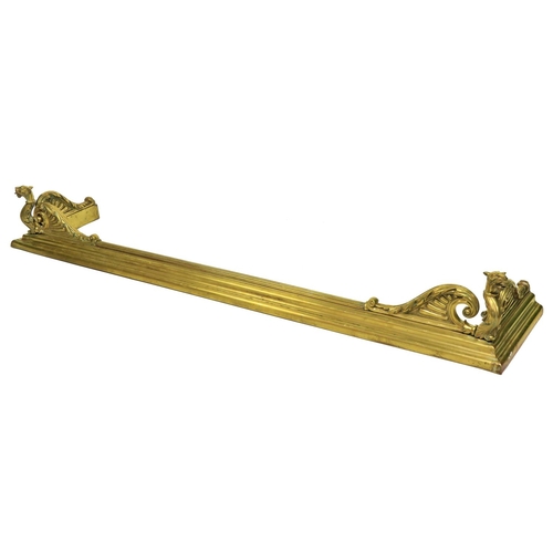 460 - An unusual 19th Century brass Fender, the front corners cast with winged gargoyles on a reeded and m... 