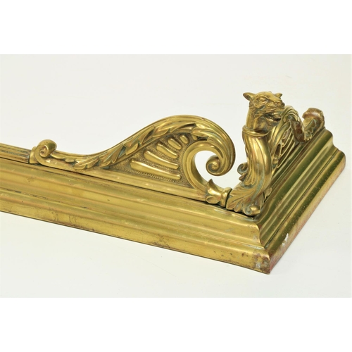 460 - An unusual 19th Century brass Fender, the front corners cast with winged gargoyles on a reeded and m... 