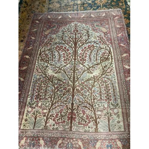 299 - A semi-antique Persian Rug, with all over tree of life design, with birds and flowers on an ivory gr... 