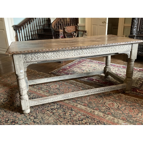 327 - A late 18th / early 19th Century oak Table,  with carved edges and reliefs, on turned legs, united b... 