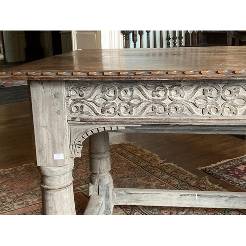 327 - A late 18th / early 19th Century oak Table,  with carved edges and reliefs, on turned legs, united b... 