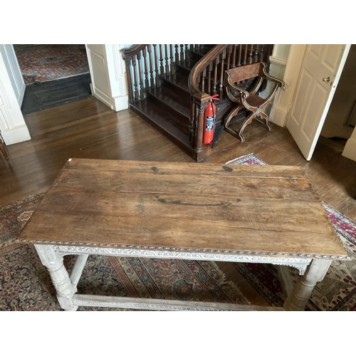 327 - A late 18th / early 19th Century oak Table,  with carved edges and reliefs, on turned legs, united b... 